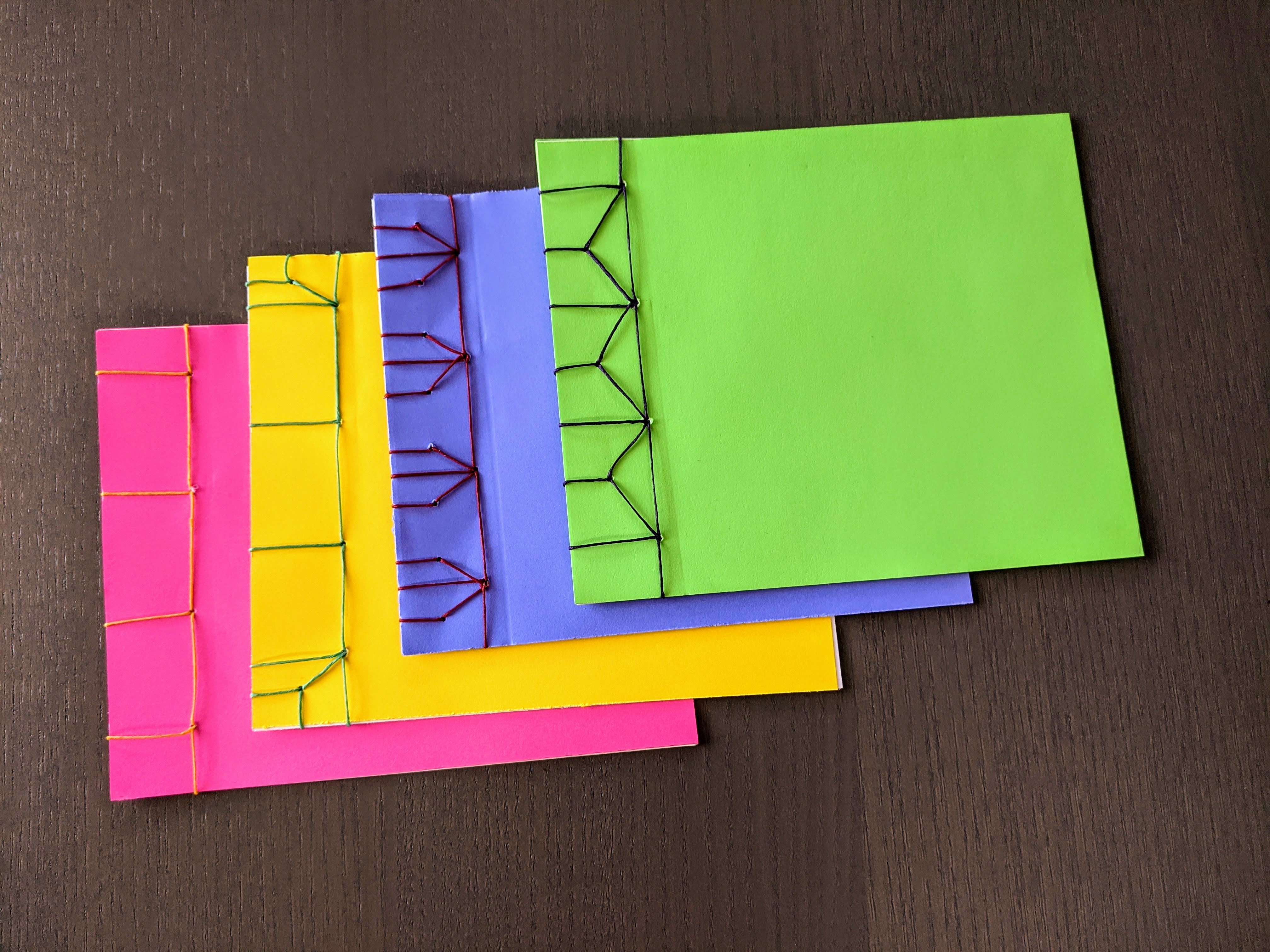 pink, yellow, blue, and green handmade books with Japanese stab bindings