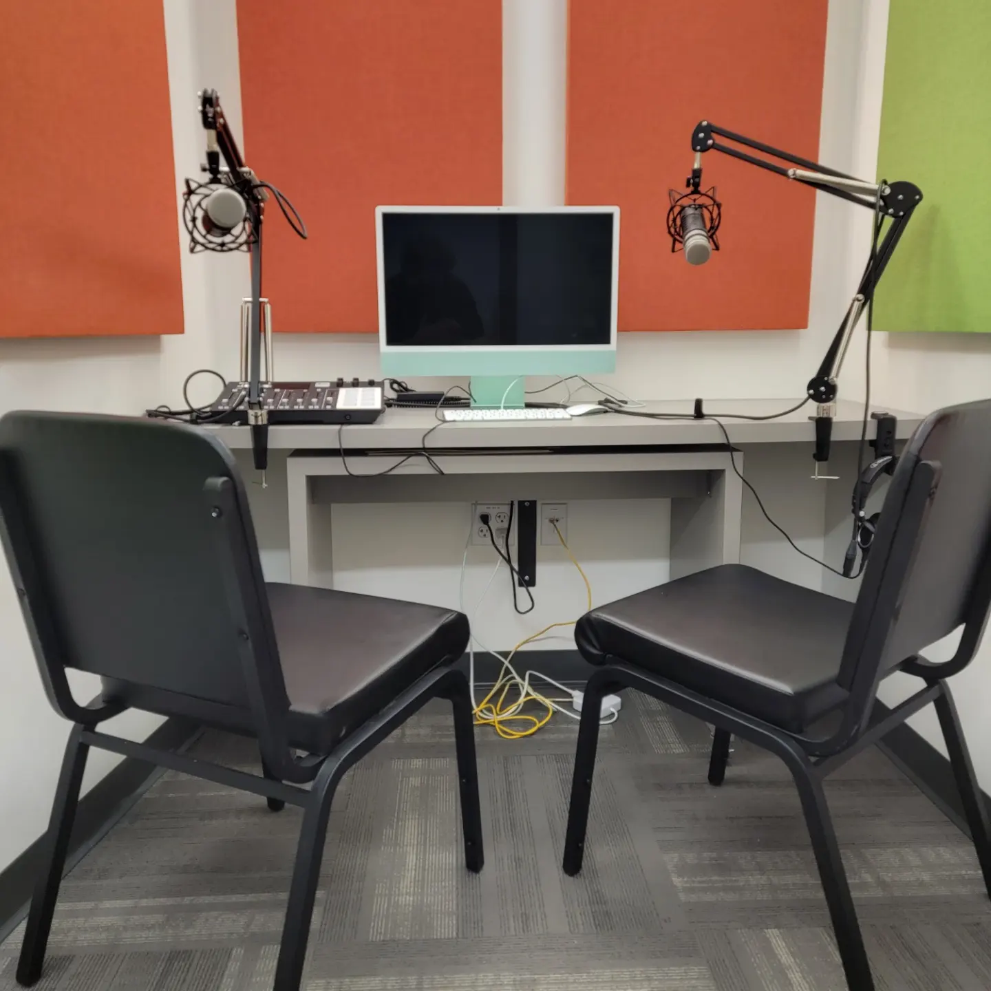 podcast studio with two chairs, iMac, editing equipment and microphones