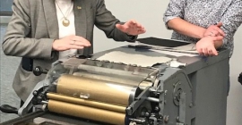 two people printing on a Vandercook proof press