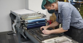 person setting type on a letterpress