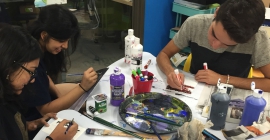 three students engaged in painting and drawing